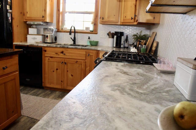 kitchen with black appliances, sink, dark hardwood / wood-style floors, decorative backsplash, and extractor fan