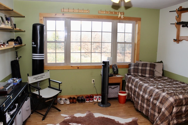 bedroom featuring ceiling fan, light wood-type flooring, and multiple windows