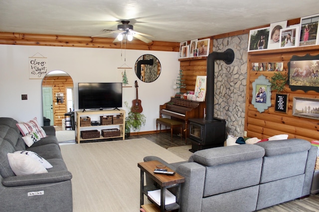 living room featuring light hardwood / wood-style flooring, a wood stove, and ceiling fan