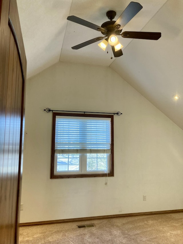 carpeted empty room with vaulted ceiling and ceiling fan