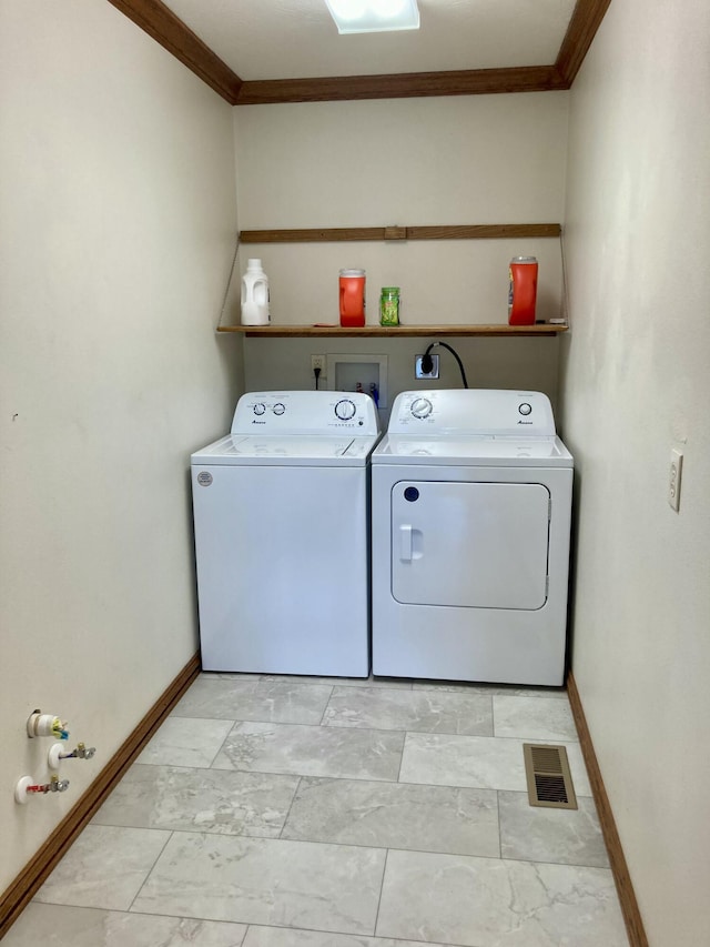 clothes washing area with independent washer and dryer and crown molding