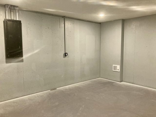 unfurnished room with electric panel and concrete flooring