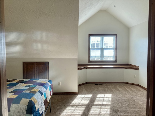 bedroom with light carpet and lofted ceiling