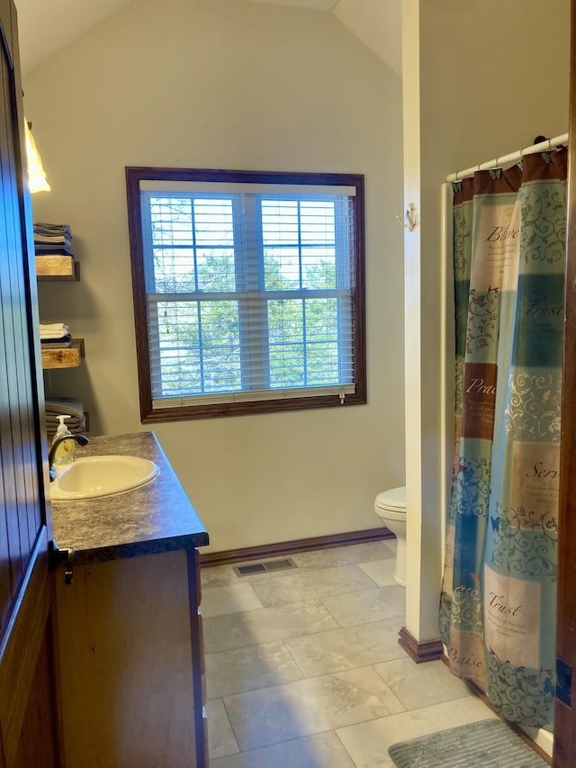 bathroom featuring a shower with shower curtain, vanity, toilet, and lofted ceiling