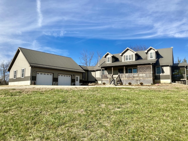 view of front of property featuring covered porch, a garage, and a front lawn