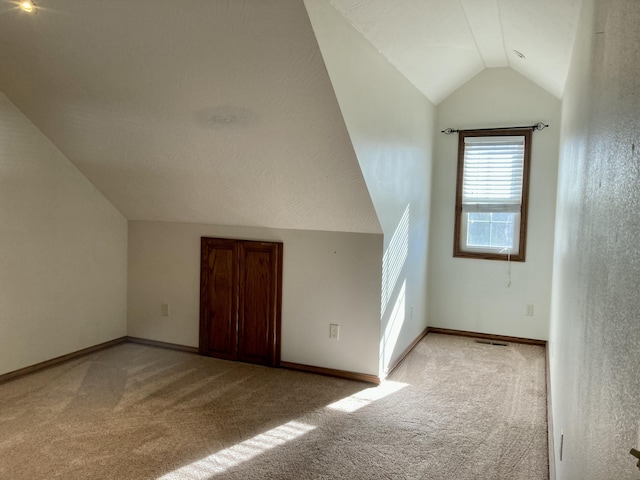 bonus room featuring light carpet and vaulted ceiling