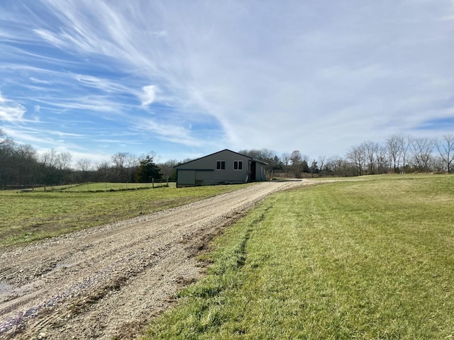 view of front of house with a front lawn and a rural view