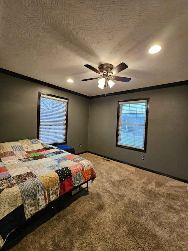 carpeted bedroom featuring ceiling fan, ornamental molding, and a textured ceiling