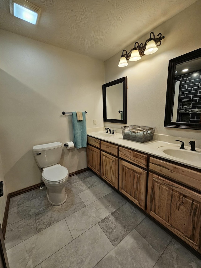 bathroom with vanity, a textured ceiling, and toilet