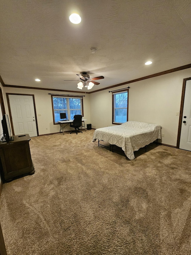 carpeted bedroom featuring multiple windows, ceiling fan, a textured ceiling, and ornamental molding