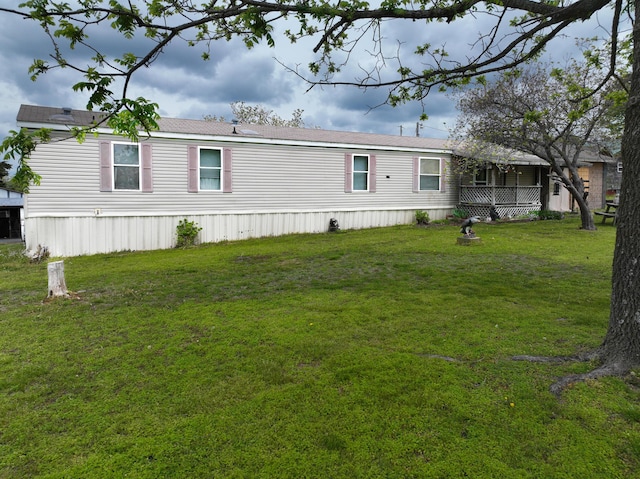 rear view of house featuring a yard