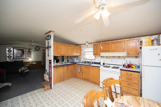 kitchen featuring lofted ceiling, ceiling fan, white appliances, and a textured ceiling