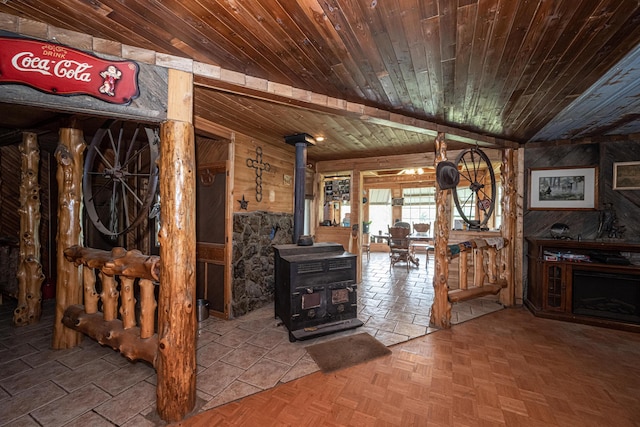 living room featuring parquet floors, a wood stove, wood ceiling, and vaulted ceiling