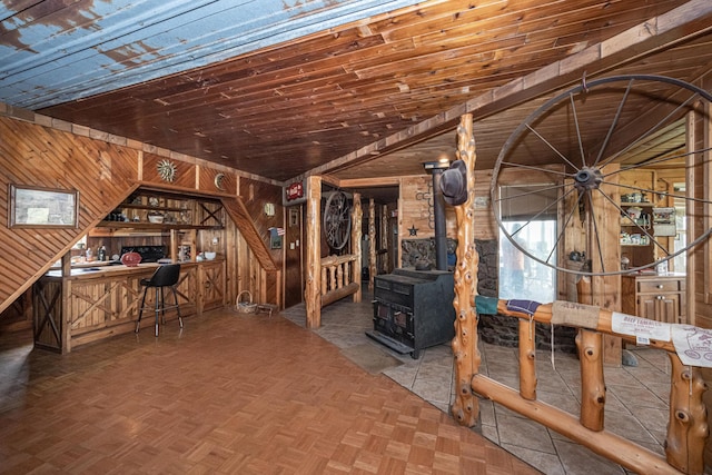 interior space with wooden walls, parquet floors, wood ceiling, and lofted ceiling