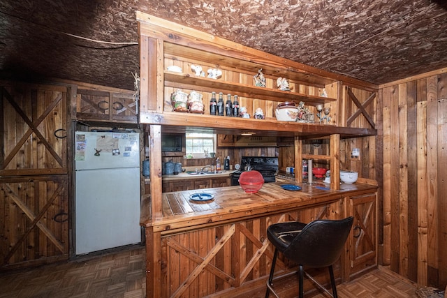 bar with dark parquet flooring, electric range, white fridge, and sink