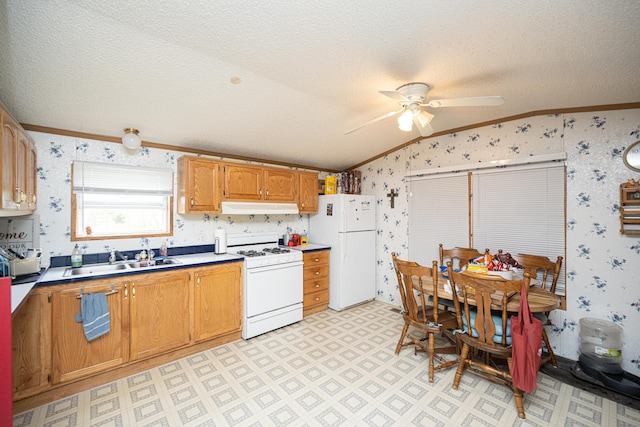 kitchen featuring a textured ceiling, white appliances, sink, and vaulted ceiling