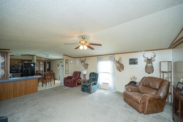 living room featuring ceiling fan, crown molding, light colored carpet, lofted ceiling, and a textured ceiling