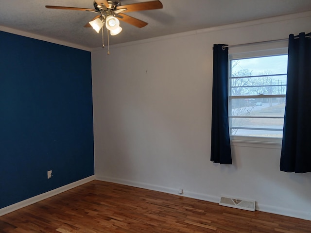 unfurnished room with ceiling fan, dark wood-type flooring, and ornamental molding