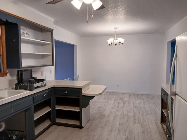 kitchen featuring white refrigerator, light wood-type flooring, decorative light fixtures, a textured ceiling, and ornamental molding