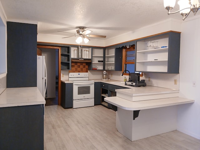 kitchen featuring kitchen peninsula, light hardwood / wood-style floors, a textured ceiling, white appliances, and a kitchen bar