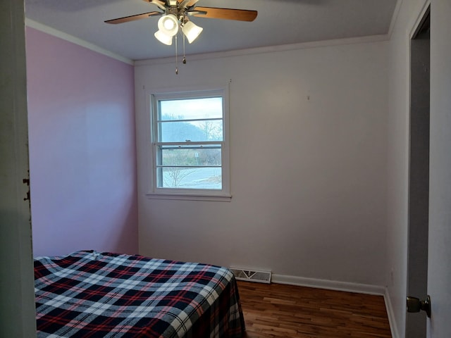 bedroom with crown molding, ceiling fan, and dark wood-type flooring