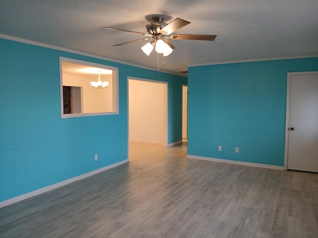 unfurnished room featuring crown molding, ceiling fan with notable chandelier, and hardwood / wood-style flooring