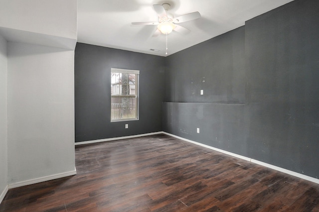 empty room featuring ceiling fan and dark wood-type flooring