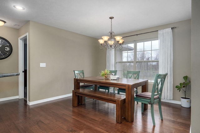 dining room with dark wood-type flooring and a notable chandelier