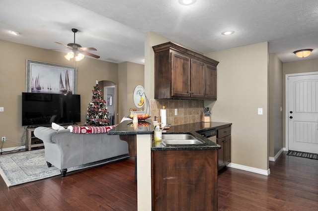 kitchen with sink, dark hardwood / wood-style floors, a textured ceiling, tasteful backsplash, and kitchen peninsula