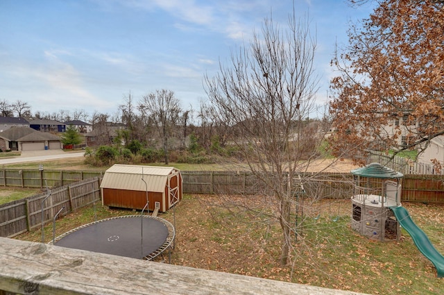 view of yard with a playground, a trampoline, and a storage unit