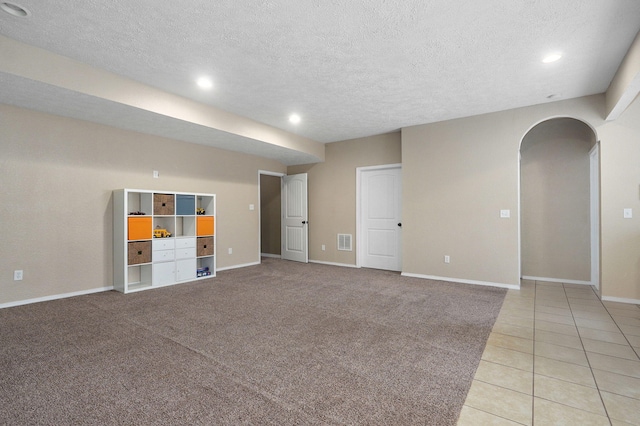 interior space with a textured ceiling and light tile patterned flooring