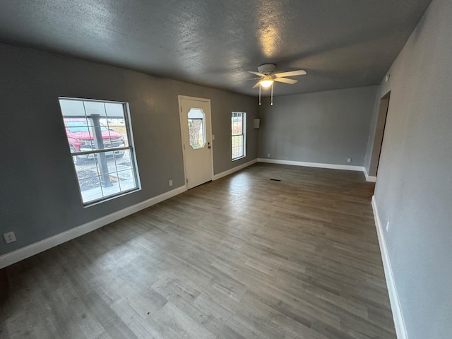 spare room featuring wood-type flooring, a textured ceiling, and ceiling fan