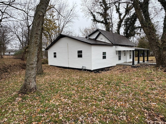 view of side of property featuring a lawn and covered porch