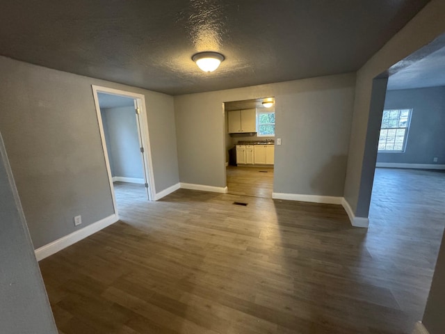 unfurnished room featuring dark hardwood / wood-style floors and a textured ceiling