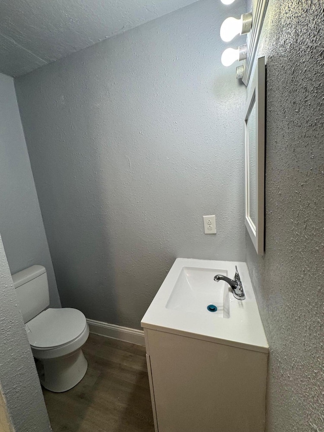 bathroom featuring vanity, wood-type flooring, and toilet