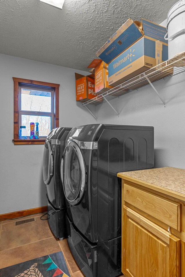 laundry room featuring washer and clothes dryer and a textured ceiling