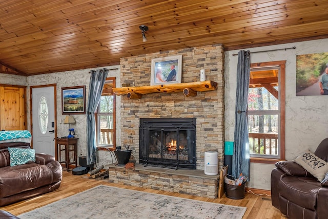 living room with a fireplace, light wood-type flooring, a healthy amount of sunlight, and wood ceiling