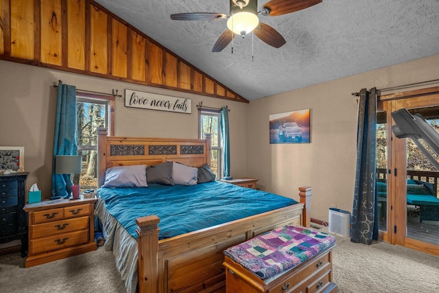 carpeted bedroom with ceiling fan, lofted ceiling, a textured ceiling, and multiple windows