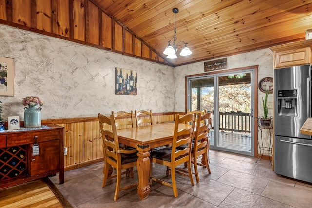 dining area with a chandelier, wooden walls, wooden ceiling, and vaulted ceiling