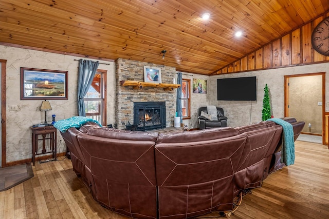 living room featuring wood ceiling, a stone fireplace, light hardwood / wood-style floors, and lofted ceiling