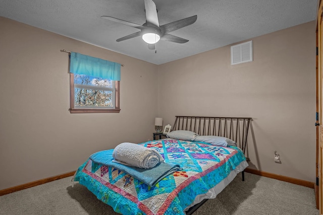 carpeted bedroom featuring a textured ceiling and ceiling fan