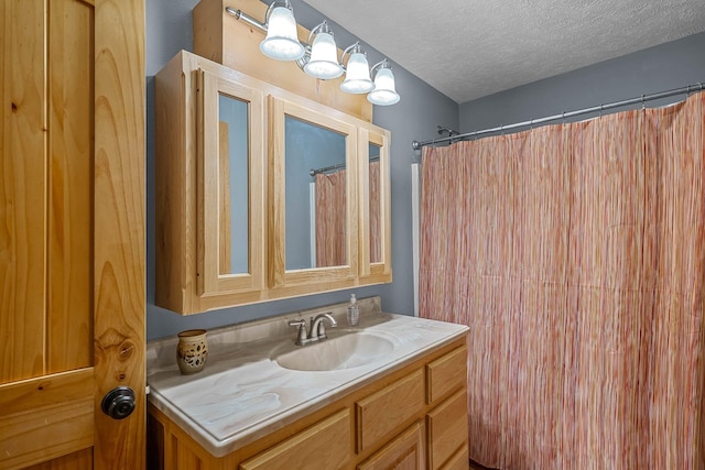 bathroom with curtained shower, vanity, and a textured ceiling