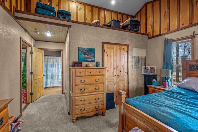 bedroom featuring light carpet and wooden walls