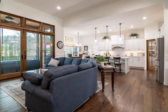 living room with french doors, dark wood-type flooring, and sink