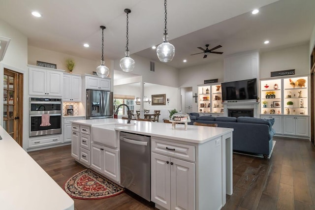 kitchen with a center island with sink, dark hardwood / wood-style flooring, white cabinetry, and stainless steel appliances