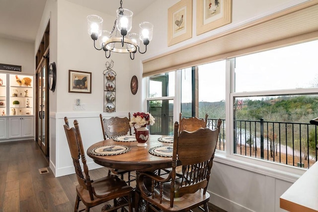 dining room featuring dark hardwood / wood-style flooring and an inviting chandelier