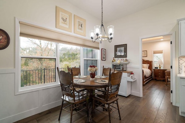 dining room with dark hardwood / wood-style flooring and an inviting chandelier