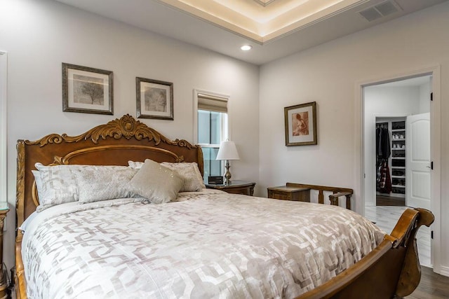 bedroom featuring a spacious closet and wood-type flooring