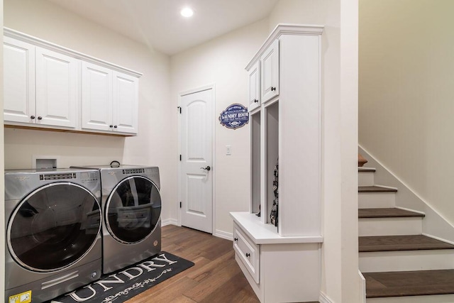 clothes washing area featuring washer and clothes dryer, cabinets, and dark hardwood / wood-style floors