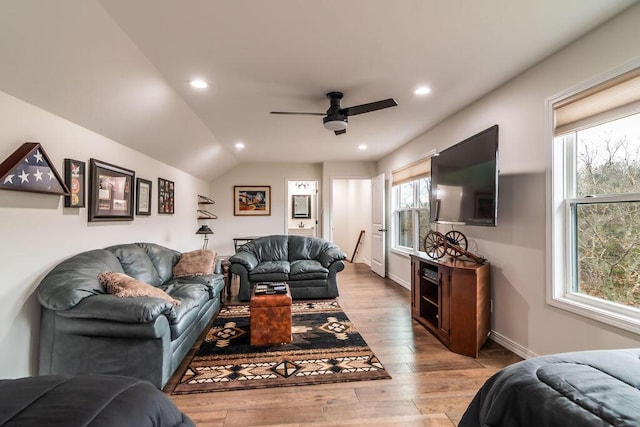 living room featuring ceiling fan, light hardwood / wood-style floors, and lofted ceiling